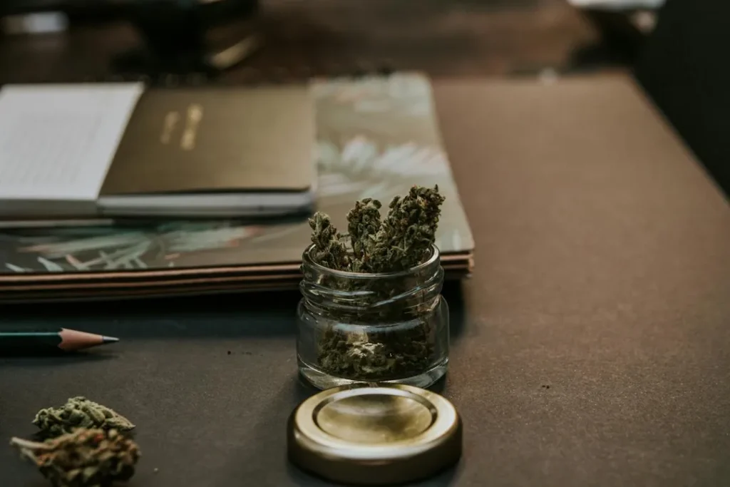 cannabis buds in jar on desk